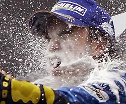 Renault's Formula One overall leader Fernando Alonso of Spain enjoys champagne after winning the German Formula One Grand Prix, his sixth victory in this year's Formula One season, at the Hockenheim race track, July 24, 2005.